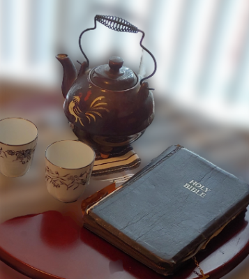 teapot and bible on end table with tea cups